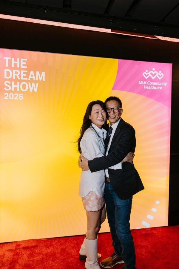 man and woman smiling in front of photo backdrop