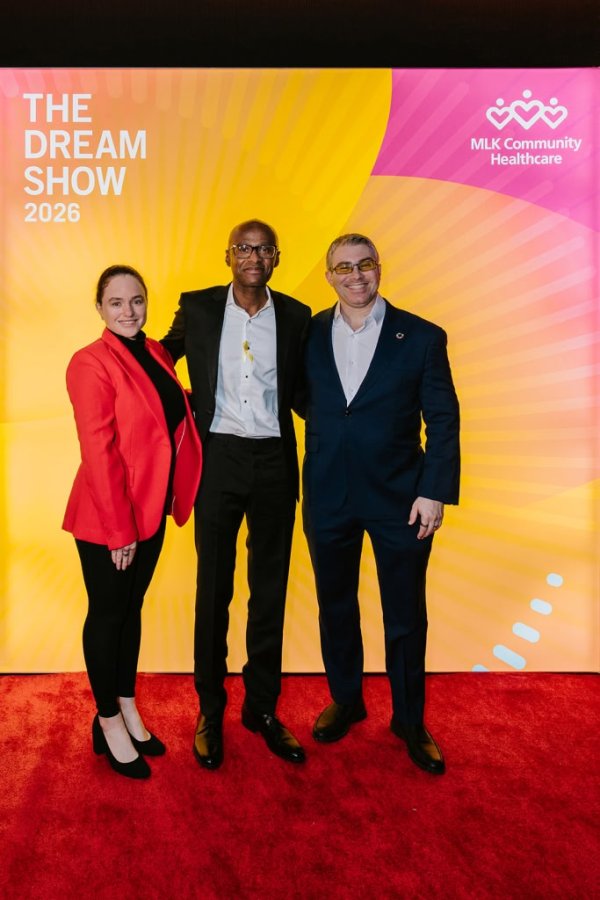 group of people smiling in front of photo backdrop
