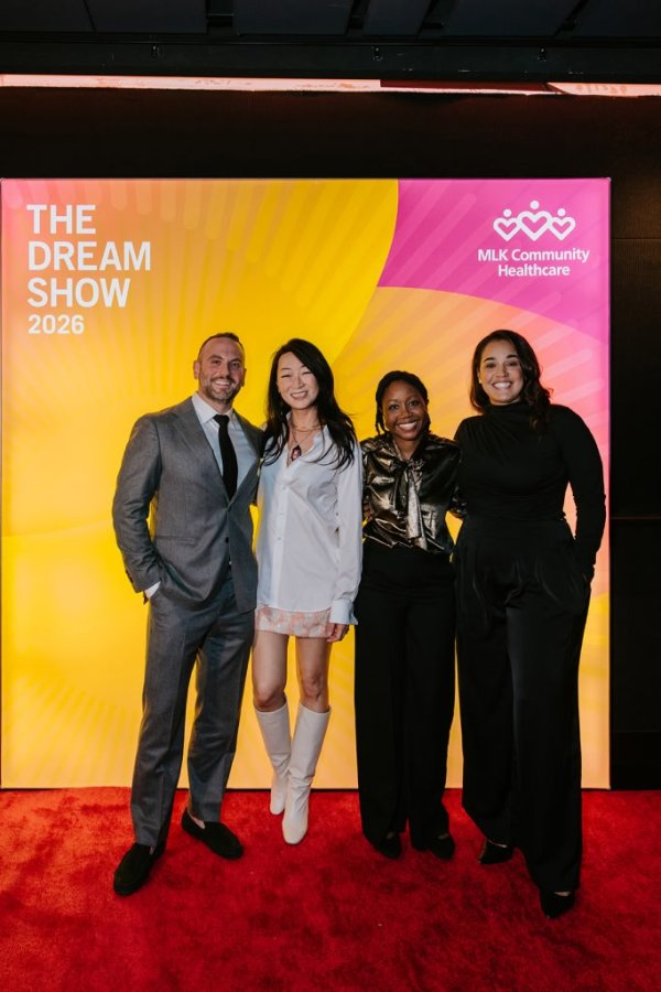 group of people smiling in front of photo backdrop