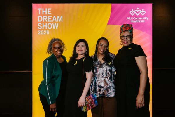 group of women smiling in front of photo backdrop