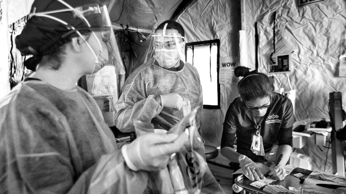 Photo of medical staff, one nurse labels blood samples