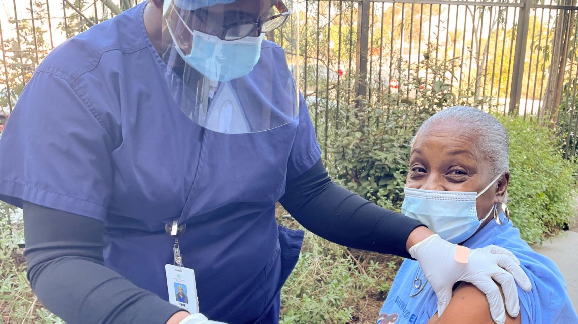 Patient seated, receiving a vaccine