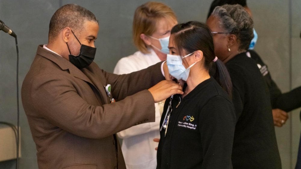 Photo of Dr. Fisher pinning an employee