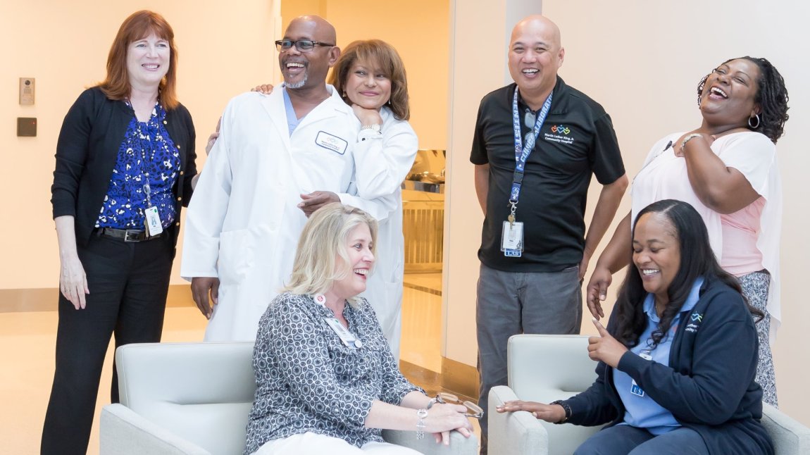 Group of seven staff members laughing