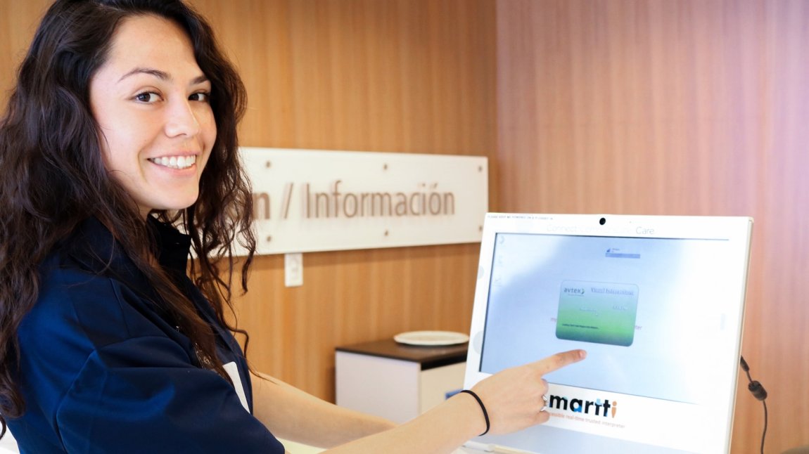 Smiling female nurse pointing at translation program on screen