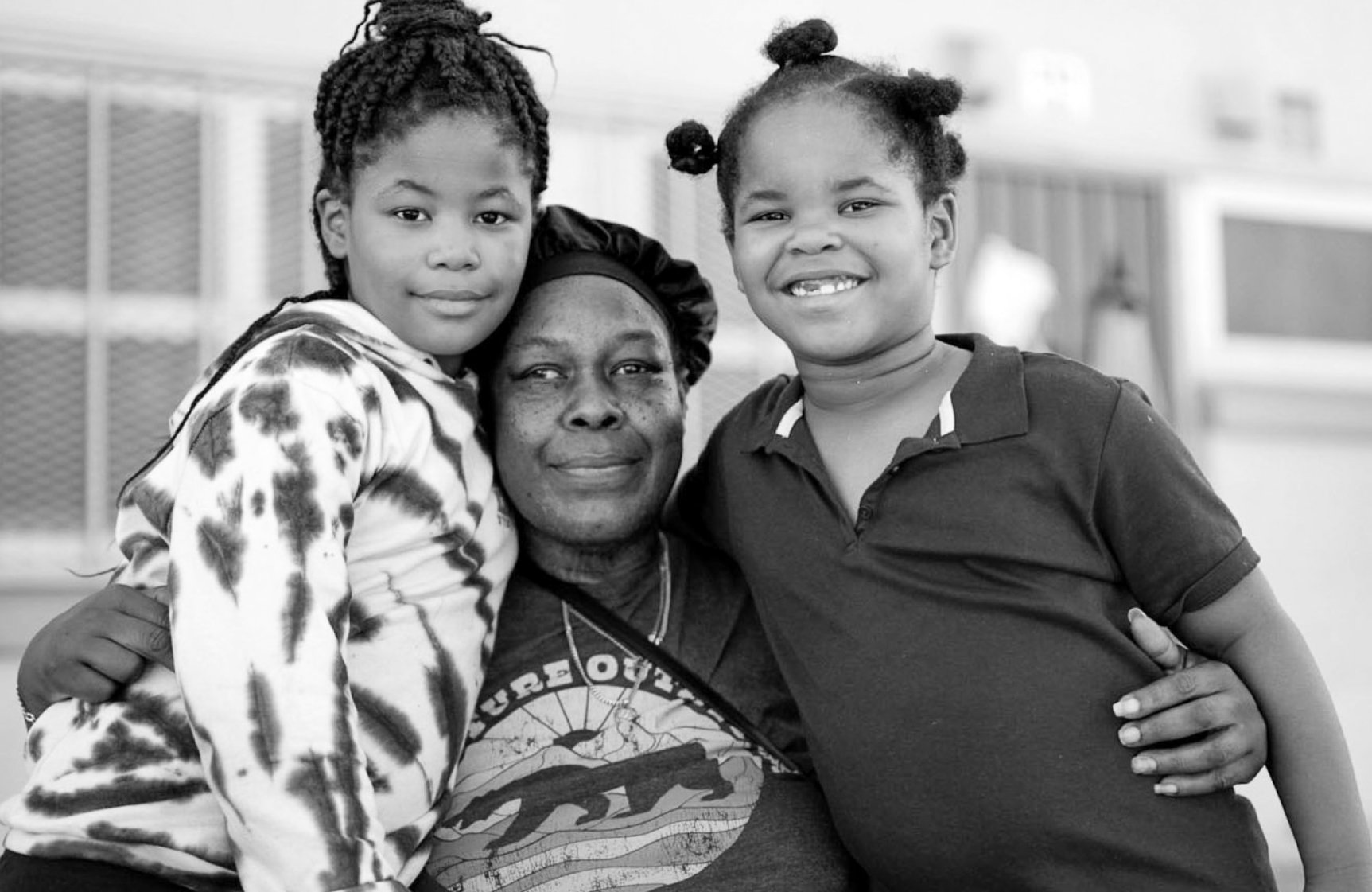 Black mother with hands around her two daughters