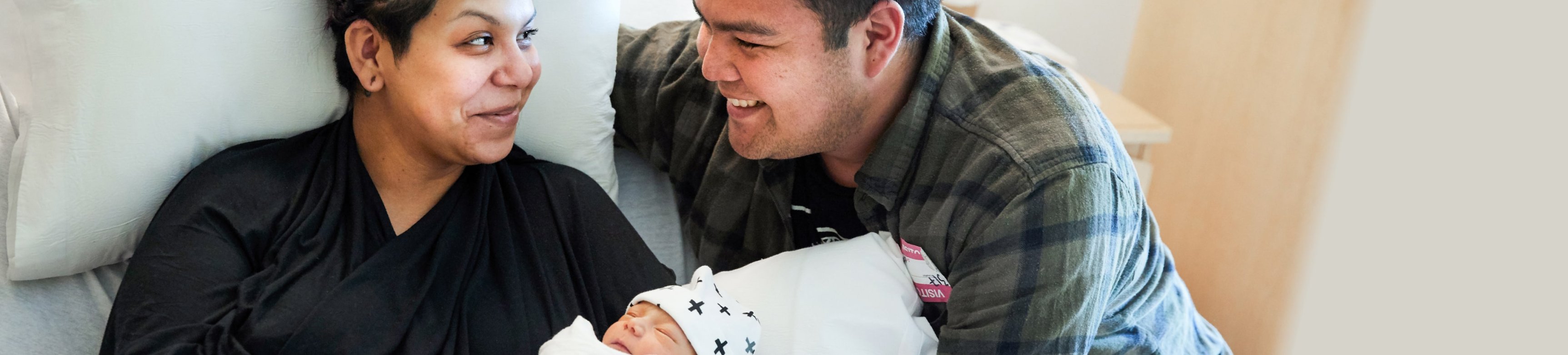 Latino mom and dad with newborn baby