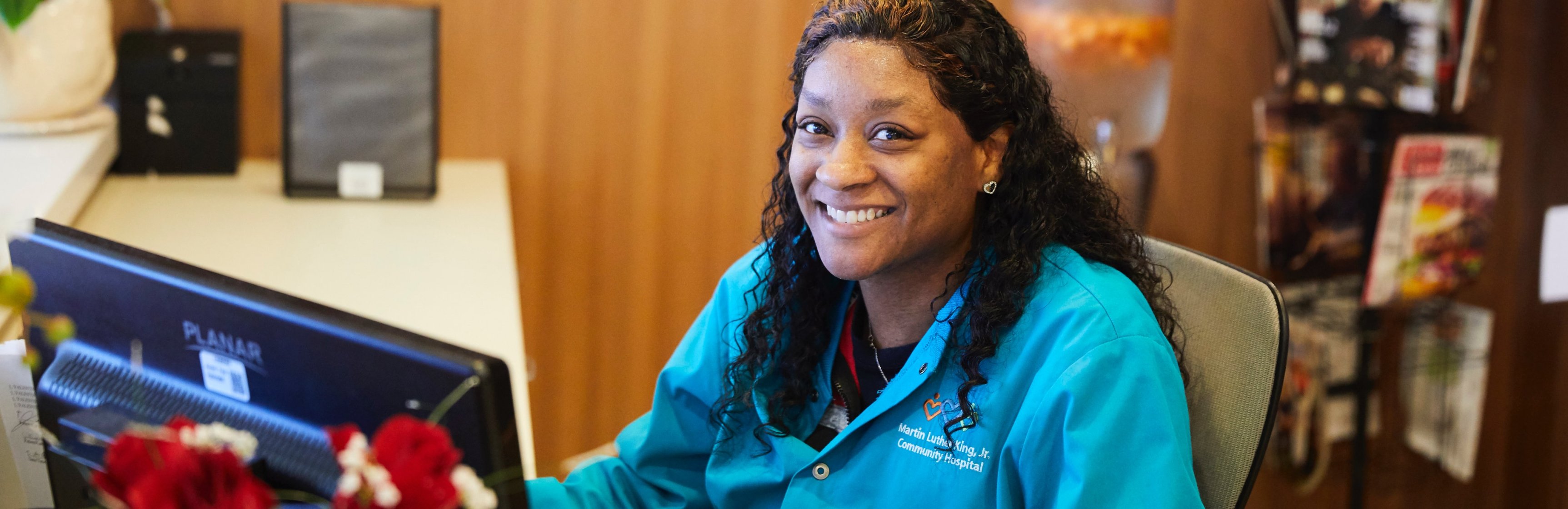 Smiling Black female nurse sitting at desk