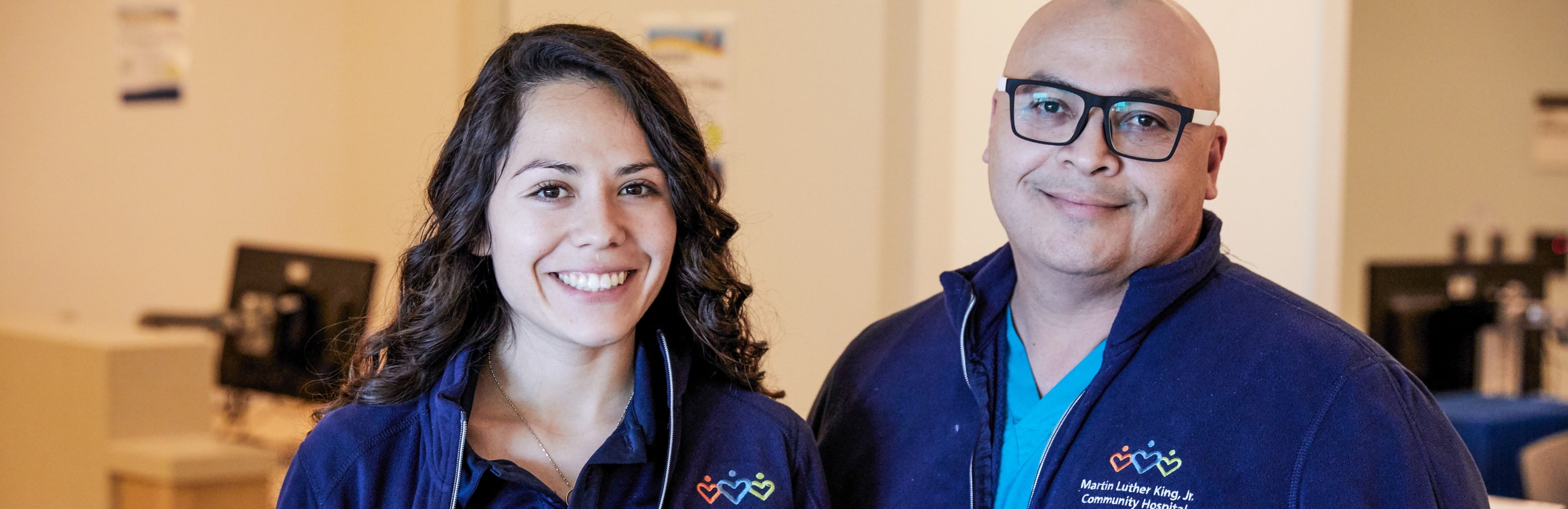 Smiling Latinx male and female wearing MLKCH jackets