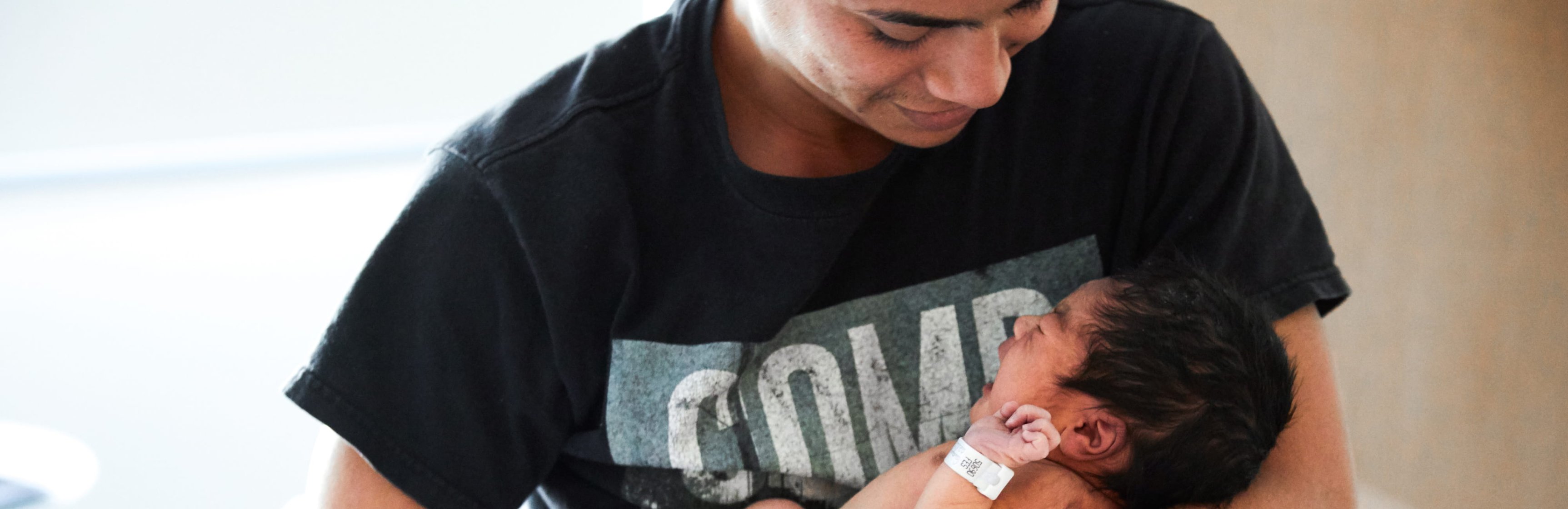 Papá sosteniendo y mirando a su bebé