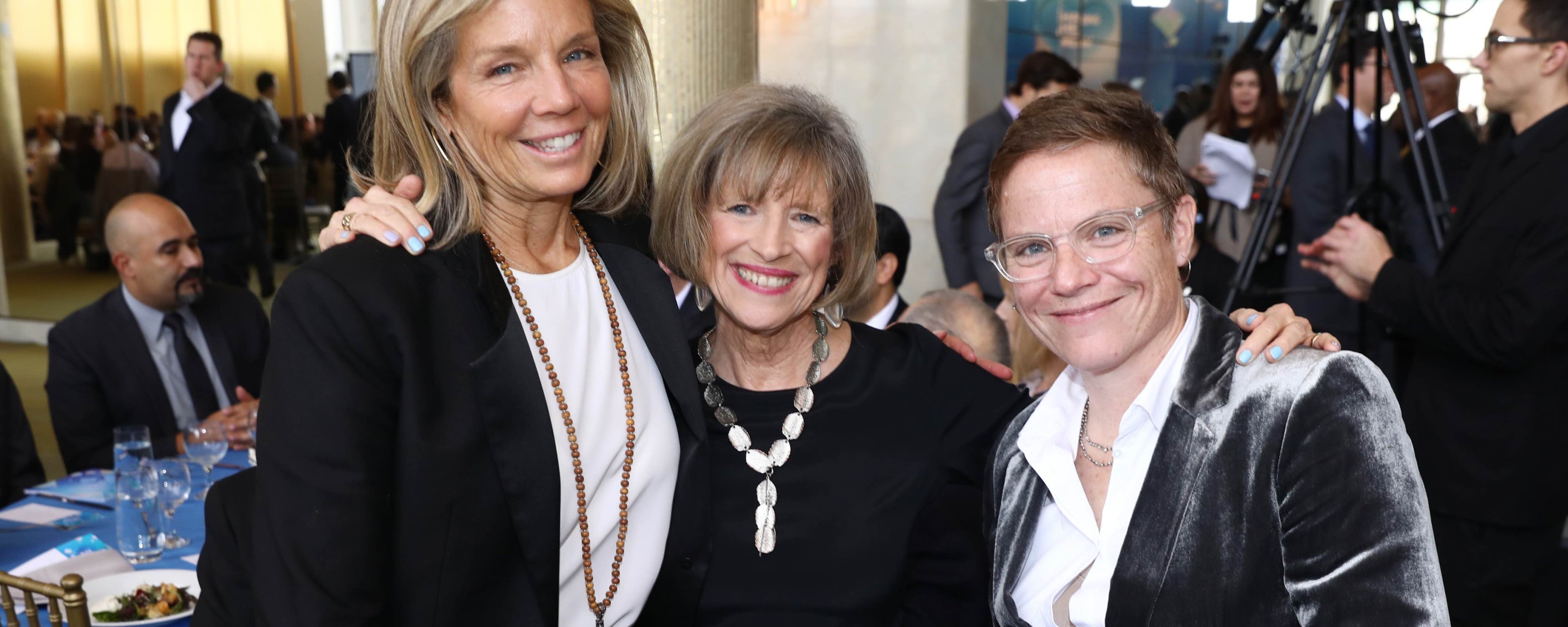 Three older white women smiling and standing together