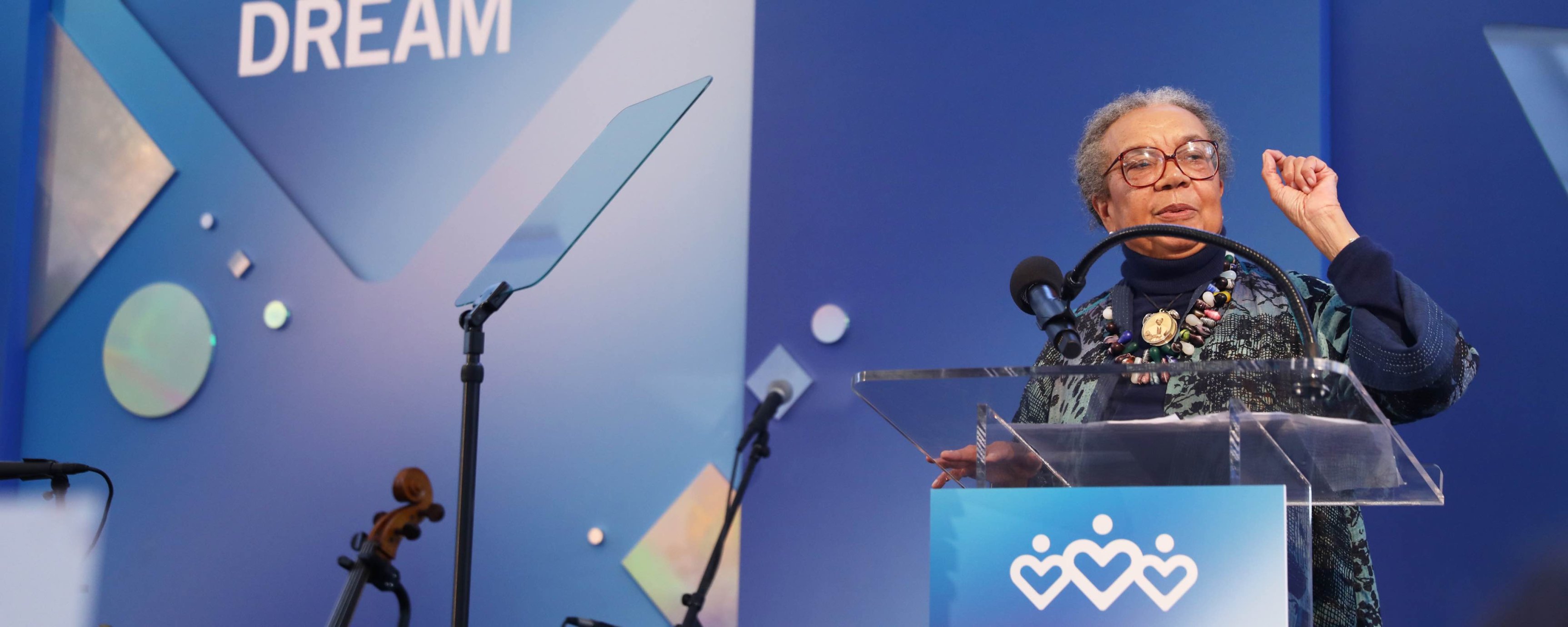 Marian Wright Edelman, an older Black woman, speaking on the Dream Lunch stage