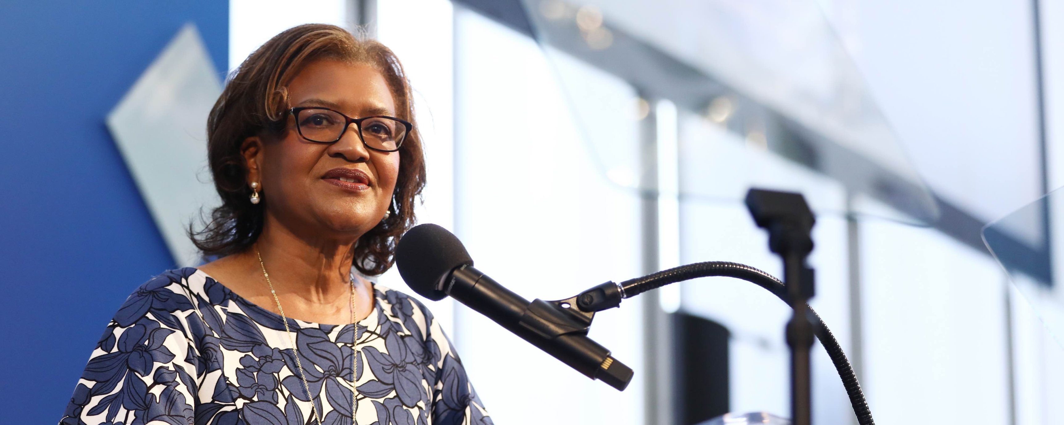 Close up of Dr. Batchlor, a middle-aged Black woman, at the Dream Lunch podium