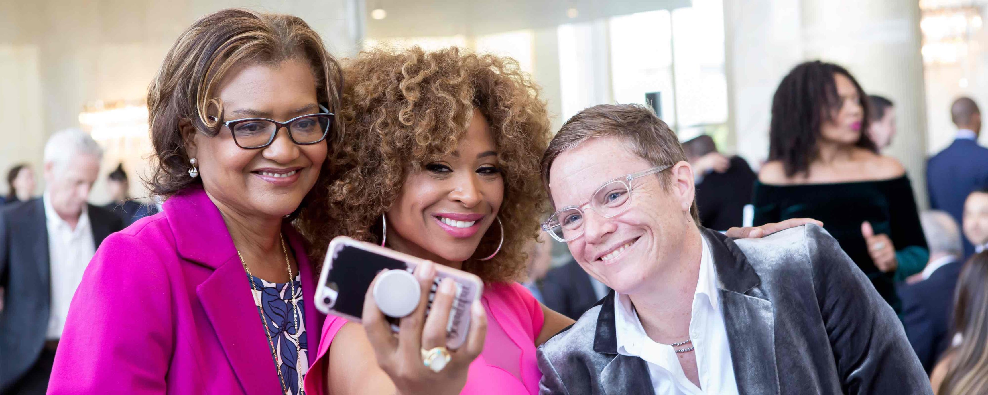 Dr. Batchlor, a middle-aged Black woman, Tanika Ray, a young Black woman, and Chris Nee, a middle-aged white woman, taking a selfie together