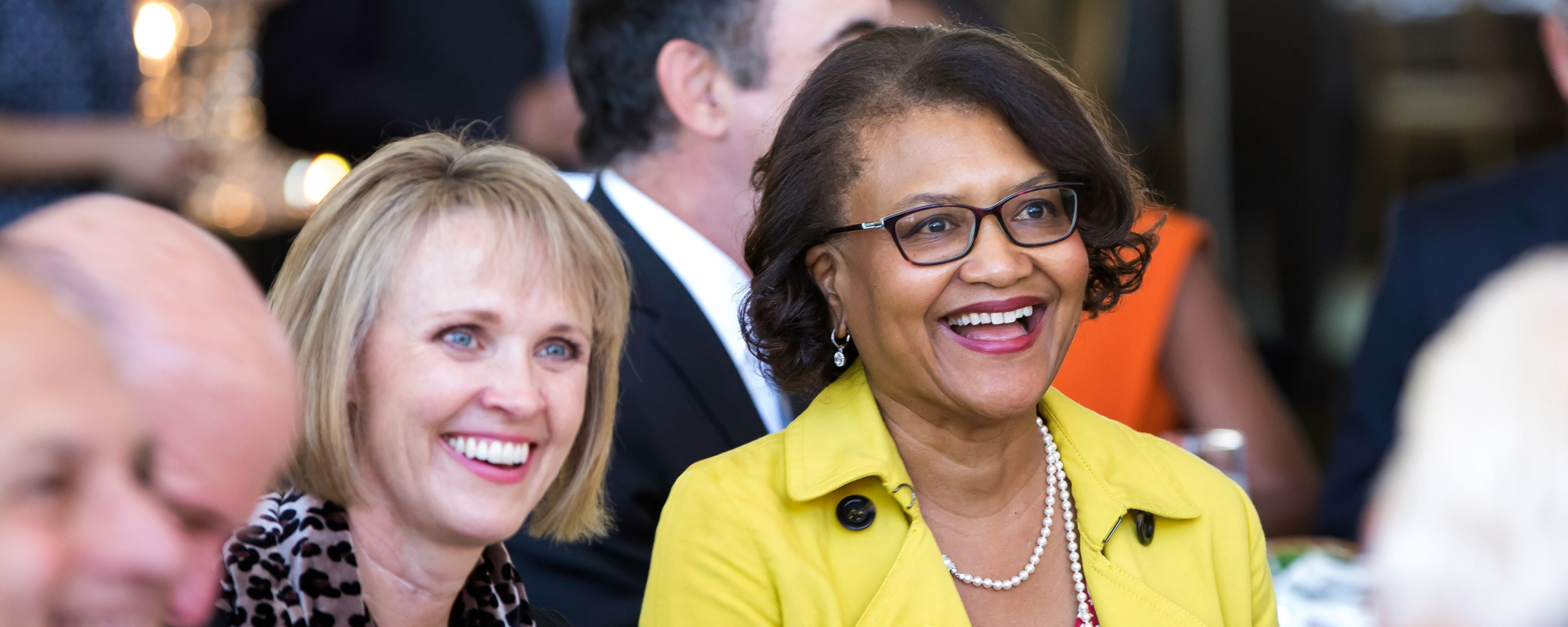 Dr. Batchlor, a middle-aged Black woman, smiling while surrounded by others at the event