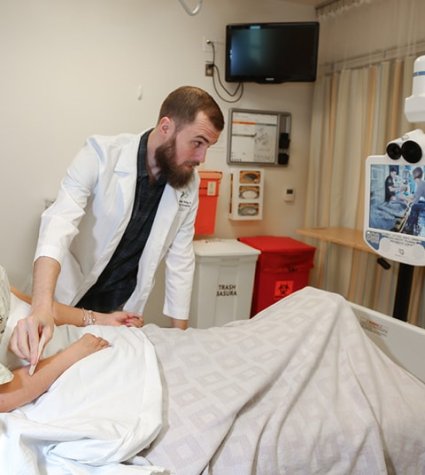 Aparato de telemedicina en uso con una paciente en una cama de hospital