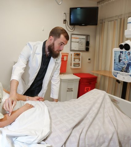 Telemedicine device in use with a female patient in a hospital bed