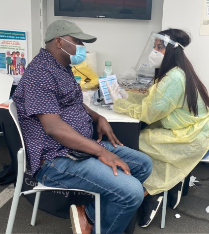 Photo of a masked patient with masked nurse