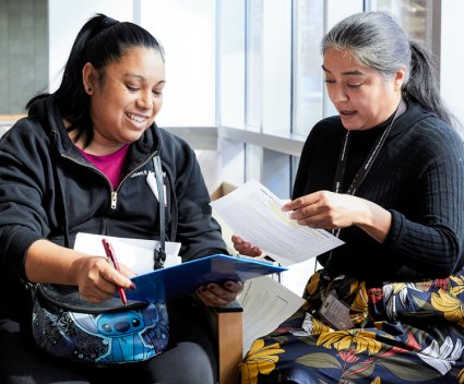 Latina patient filling out forms with Latina hospital administrator