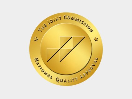 Credencial dorada con la inscripción: The Joint Commission National Quality Approval