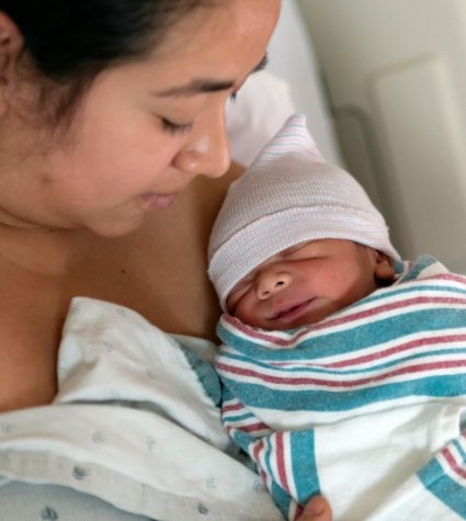 Foto de una madre hispana con su hijo recién nacido