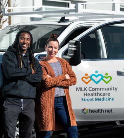 Photo of two diverse street team medicine team members in front of the street medicine truck