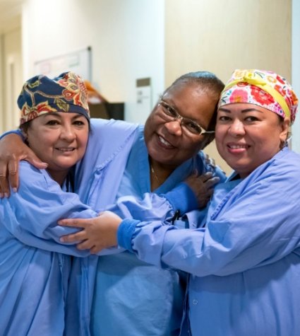 Photo of three nurses hugging