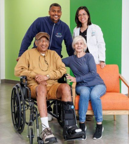 Photo of four people, one in a wheelchair
