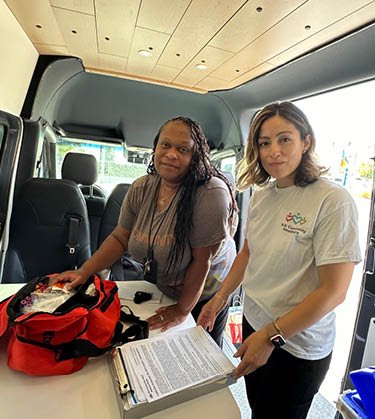 Staff member smiling with patient inside of Street Medicine truck