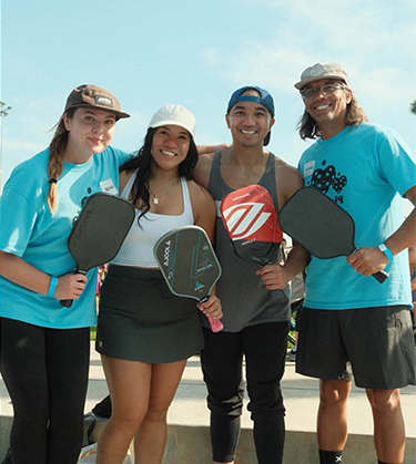 People holding pickleball paddles