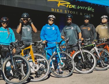 Photo of 5 people standing next to their bikes