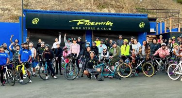 Groups people next to their bikes, ready to ride