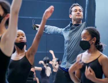 Male white dance instructor dancing with young black girls