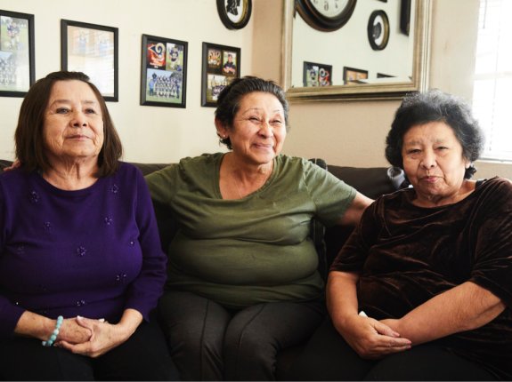 Tres hermanas mayores latinas sentadas en su hogar