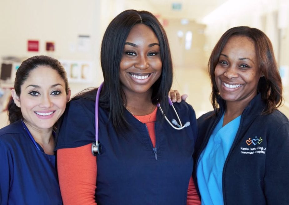 Three MLKCH nurses standing together smiling at looking at the camera