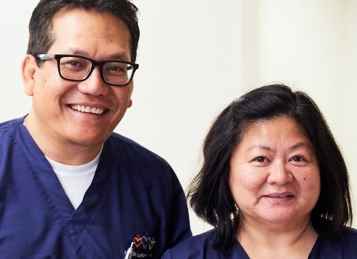 Middle aged Asian man smiling next to middle aged Asian woman