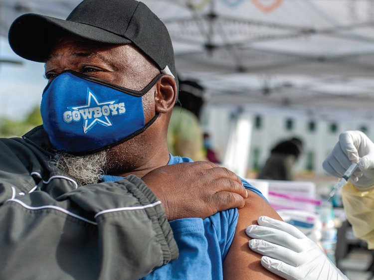 Black male patient wearing mask and receiving shot