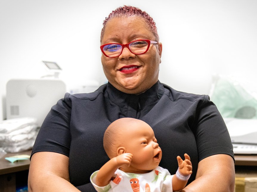 Lydia Boyd holding a prop baby in her lap