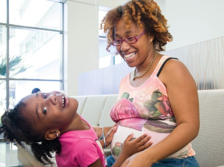Foto de una mamá de AA embarazada con su hija_Media Text Horiz