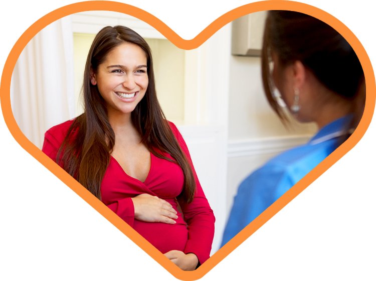 Foto de una madre hispana y una profesional de la salud en un corazón naranja
