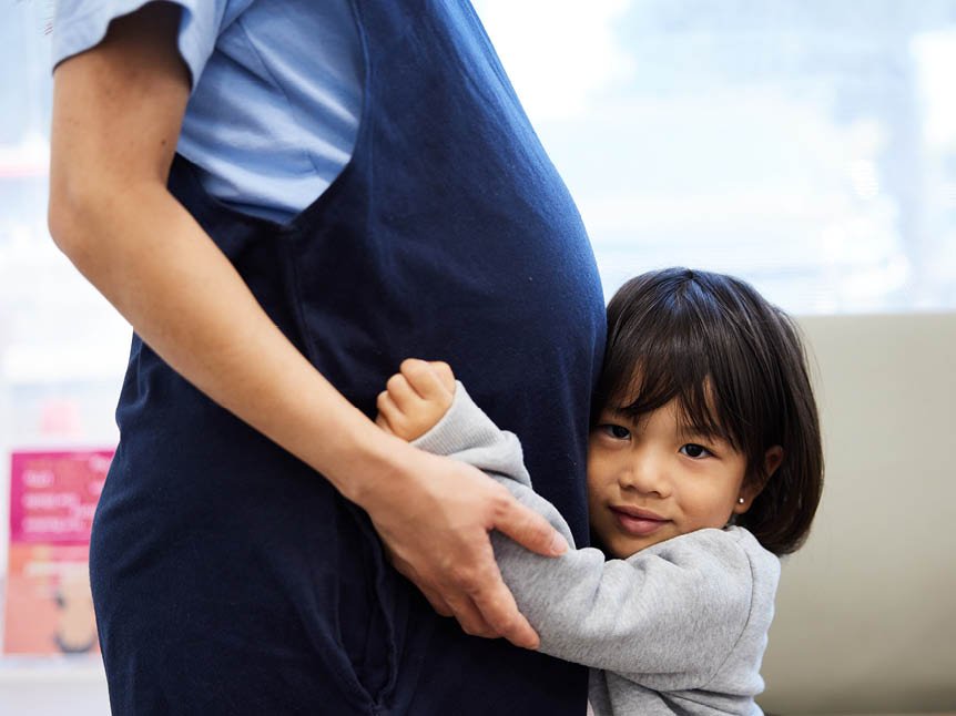 Child hugging pregnant mom