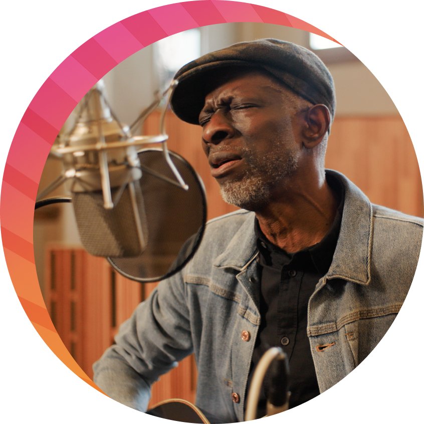 Photo of Keb' Mo' playing his guitar and sinigng into a mic