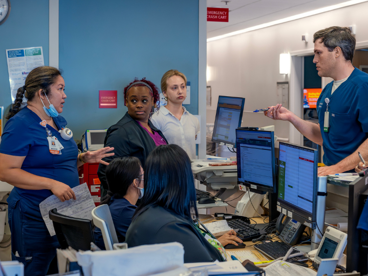 MLKCH staff members sitting in front of a computer.
